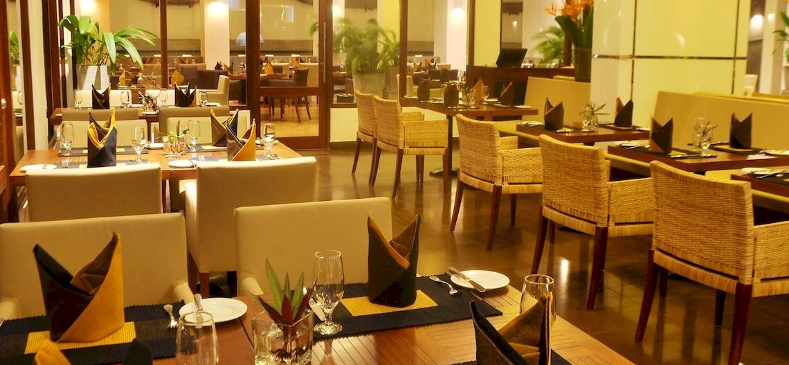 Restaurant-Innenbereich des Blue Water Hotel and Spa mit gedeckten Tischen und Stühlen.