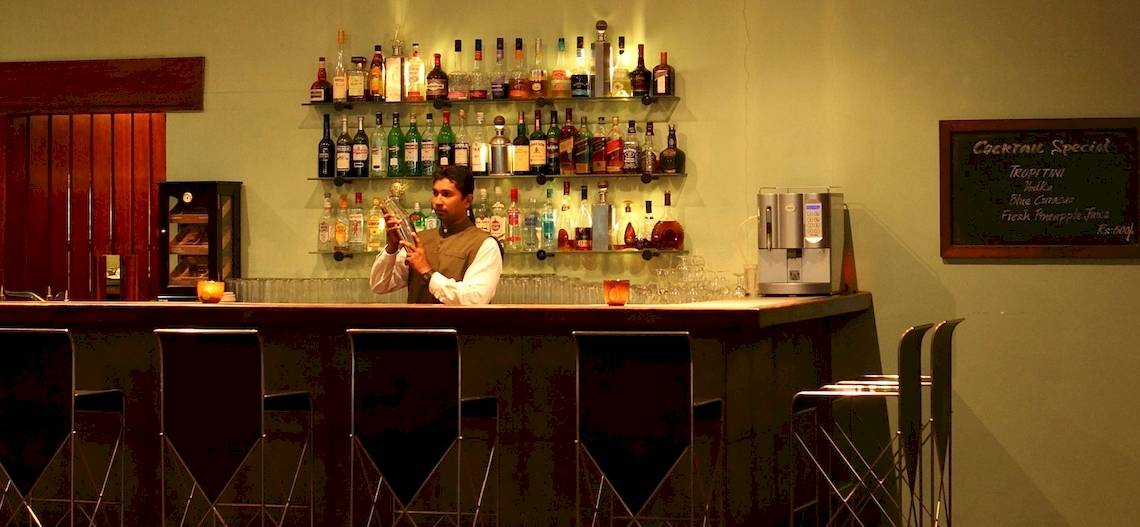Ein Barkeeper im Blue Water Hotel und Spa serviert Getränke an der Bar.
