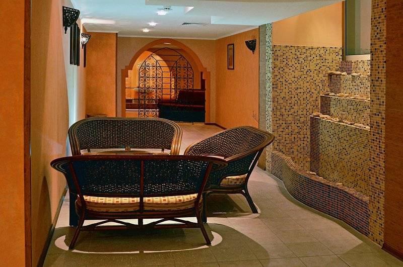 Innenbereich des Festa Panorama Hotels mit Lounge-Bereich, Möbeln und Wandverkleidung.