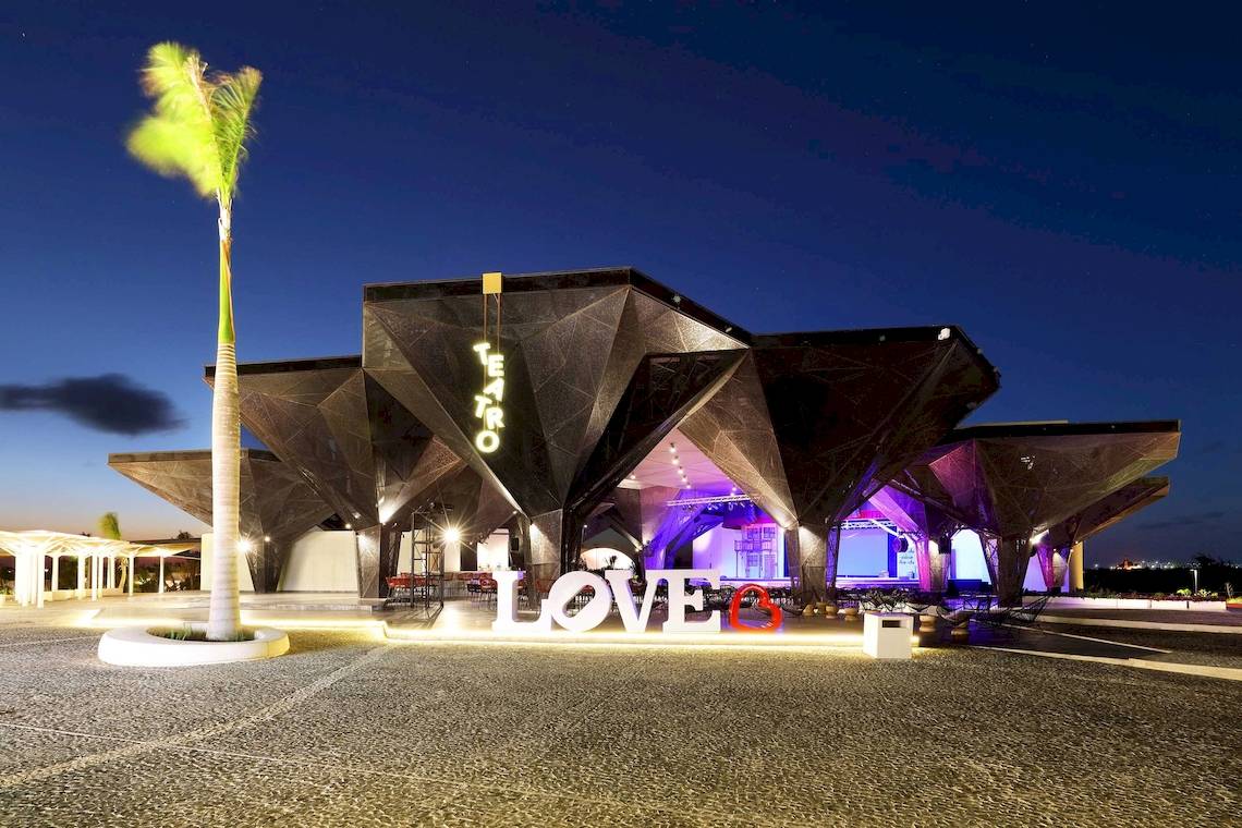 Nachtansicht des Grand Palladium Costa Mujeres Resort & Spa mit einer großen LOVE-Installation vor der Bühne.
