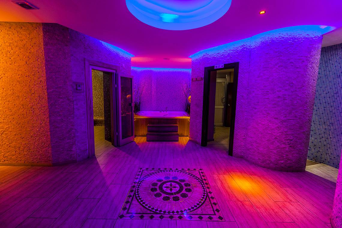Saunabereich im Eftalia Aqua Resort mit lila Beleuchtung und zentralem Designboden.