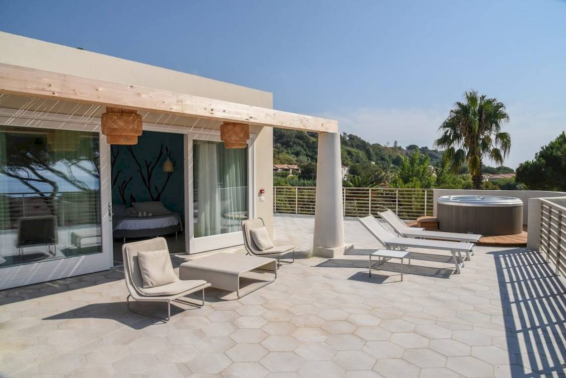 Terrasse des Baia del Sole Hotels mit Lounge-Sesseln und Whirlpool im Freien