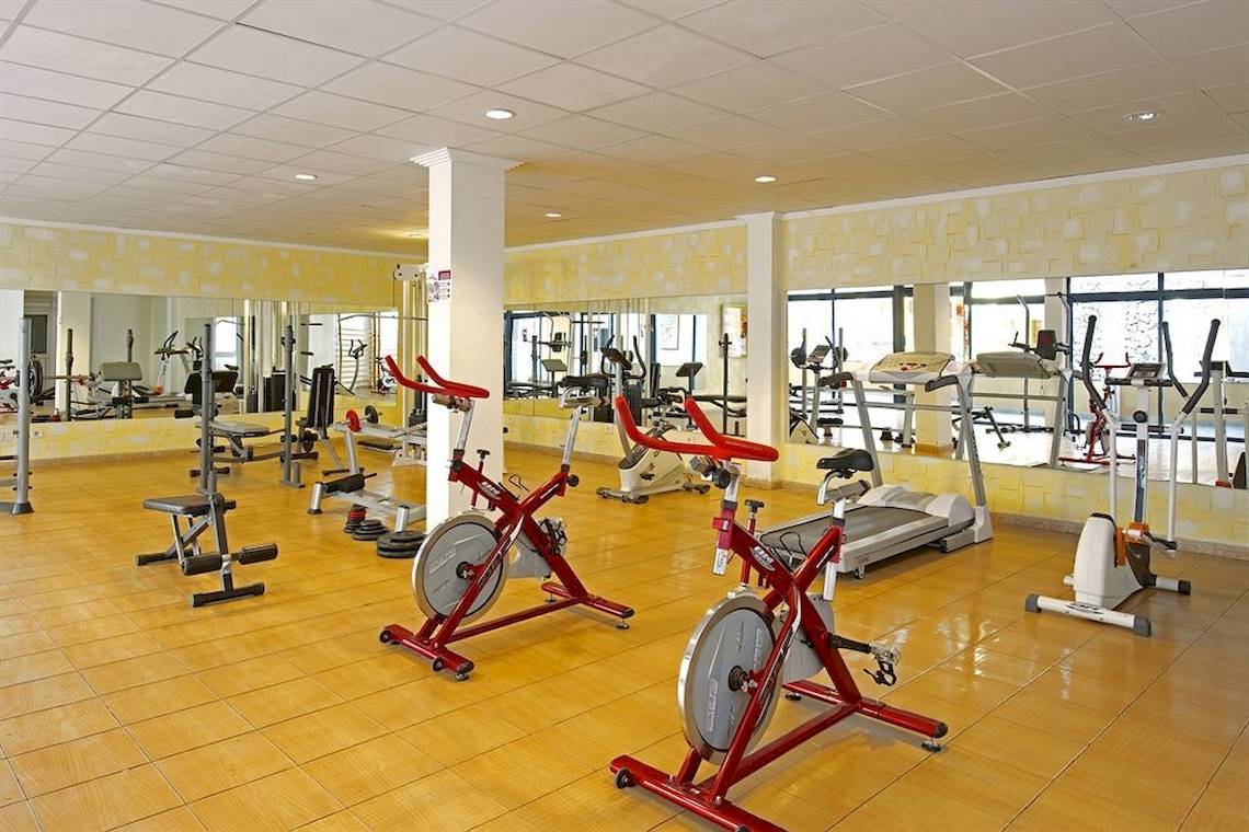 Fitnessstudio im Mirador Papagayo by LIVVO Hotel mit diversen Trainingsgeräten und Spiegeln.
