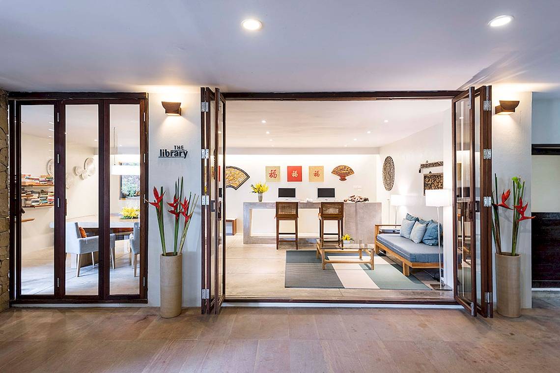 Eingangsbereich der Bibliothek im Tubkaak Krabi Boutique Resort mit offenen Türen und Inneneinrichtung.