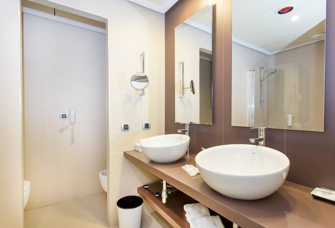 Badezimmer im Sarena de Muro Resort Mallorca mit zwei Waschbecken und Spiegeln.