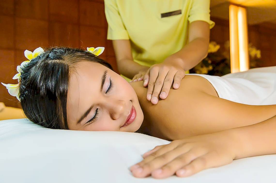 Eine Frau genießt eine Massage im Spa des Seaview Patong Hotels, während eine Therapeutin ihr hilft.