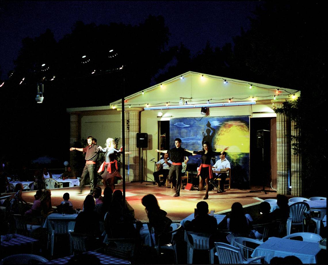 Abendveranstaltung im Hotel Calypso Beach mit Tänzern auf der Bühne und Publikum in weißen Stühlen.