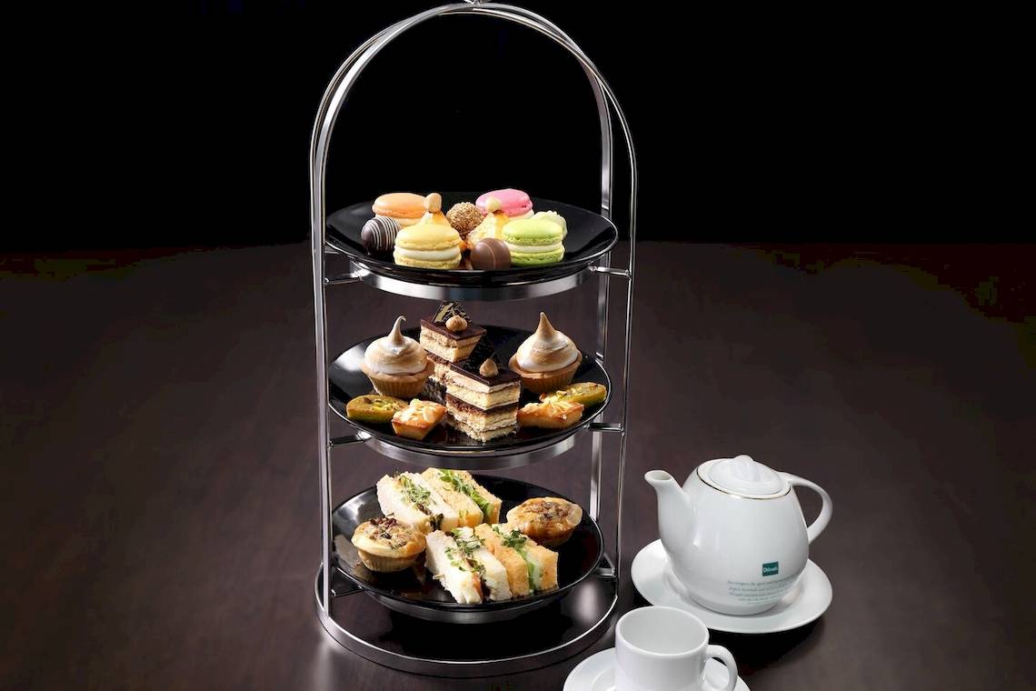 Hochwertiges Nachmittagstee-Set im Le Meridien Phuket Beach Resort mit verschiedenen Kuchen und Gebäck auf drei Etagen.