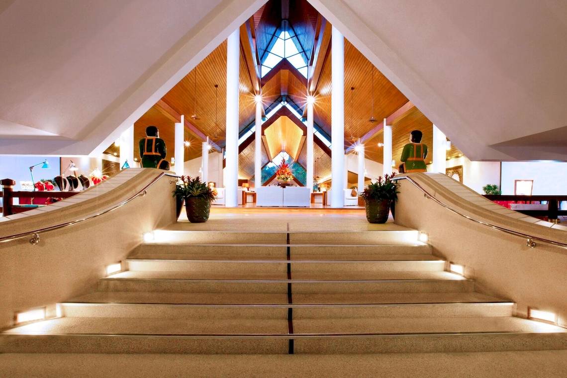 Treppen im Foyer des Le Meridien Phuket Beach Resorts mit Beleuchtung und Statuen.