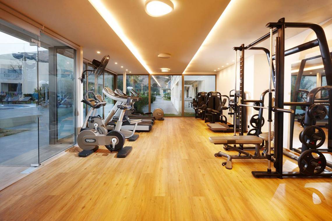 Fitnessstudio im Anna's House mit modernen Geräten und Holzboden.