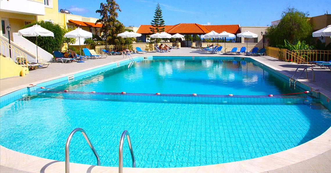 Ein großer Swimmingpool im Freien mit blauen Liegestühlen und Sonnenschirmen im Alexander House Hotel.
