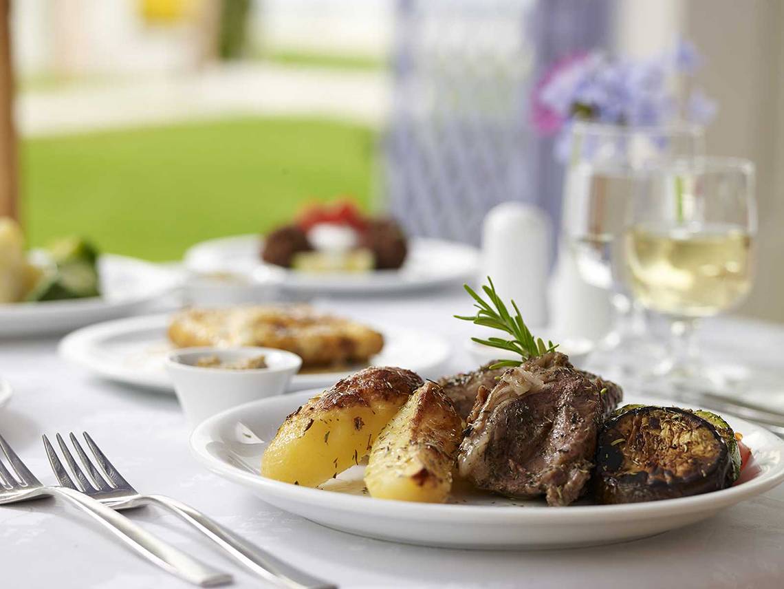 Grillplatte mit Steak, Kartoffeln und Gemüse auf dem Tisch im Serita Beach Hotel.