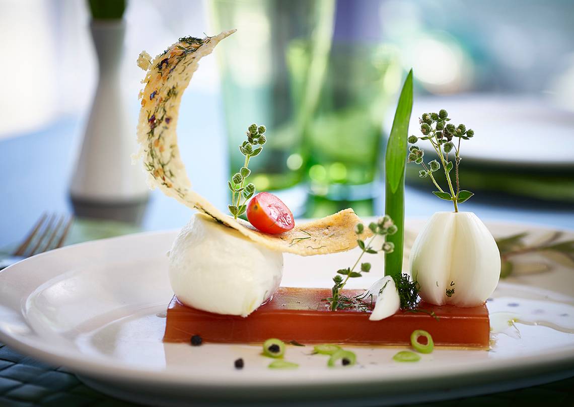 Gedeckter Tisch im Serita Beach Hotel mit einem Gericht aus Mozzarella, Tomaten und Gemüse.