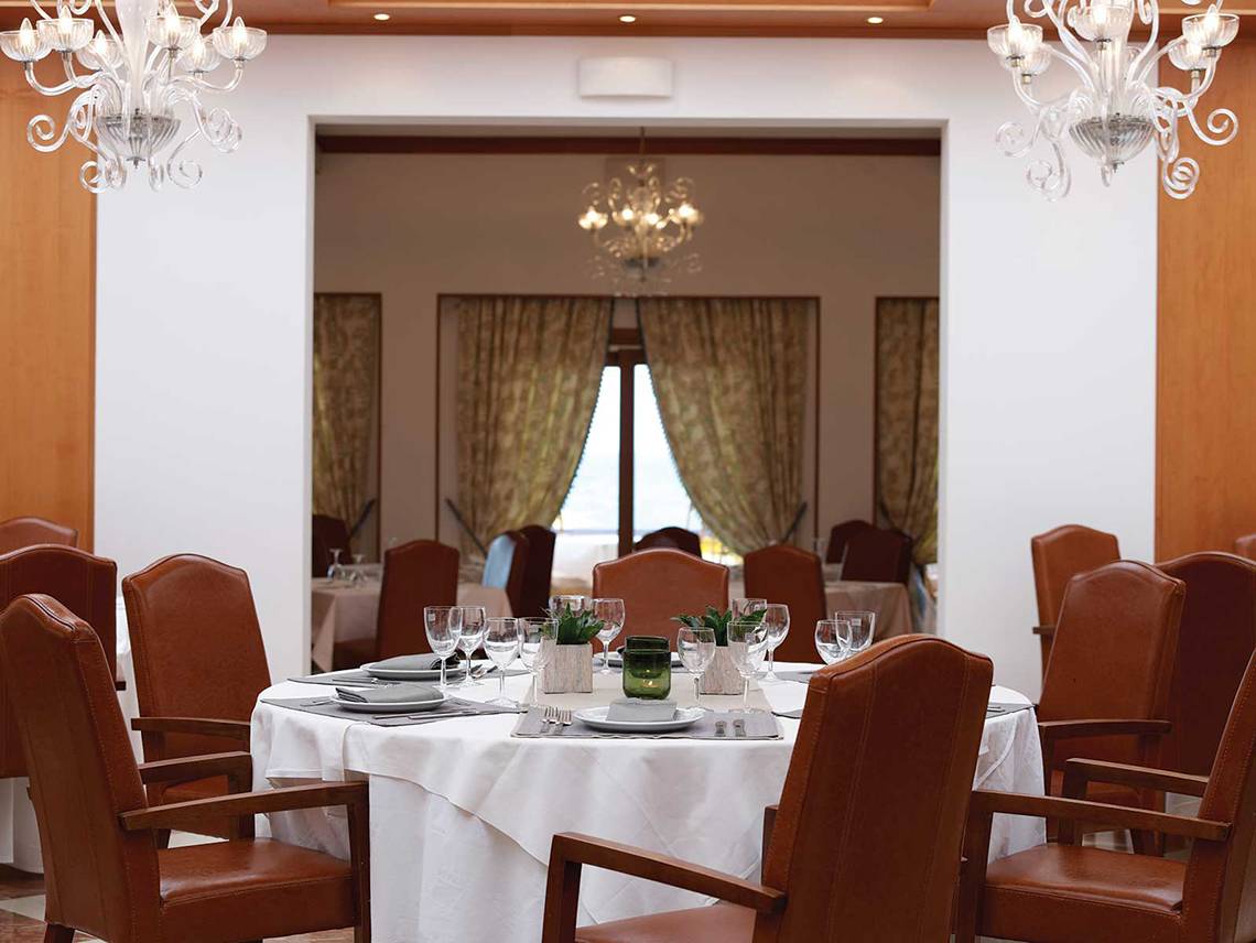 Innenansicht des Restaurants im Serita Beach Hotel mit gedecktem Tisch und eleganten Leuchten