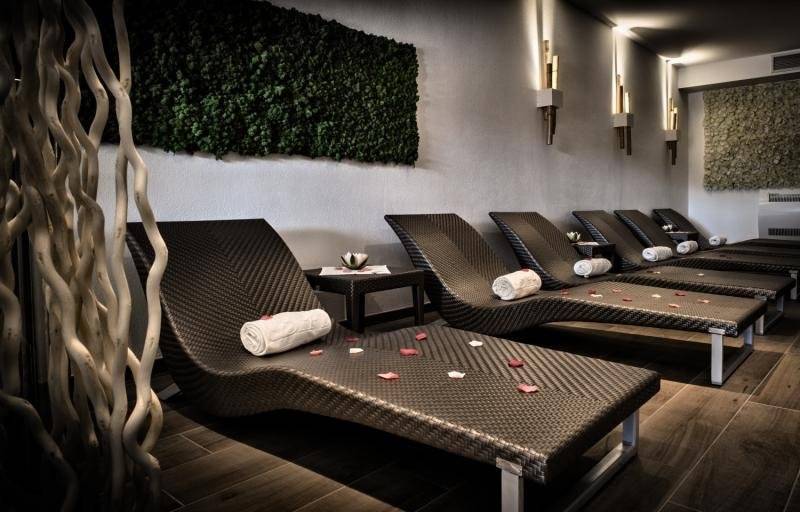 Spa-Bereich im Grand Hotel Resort Ma&Ma mit mehreren Liegen und grüner Wand