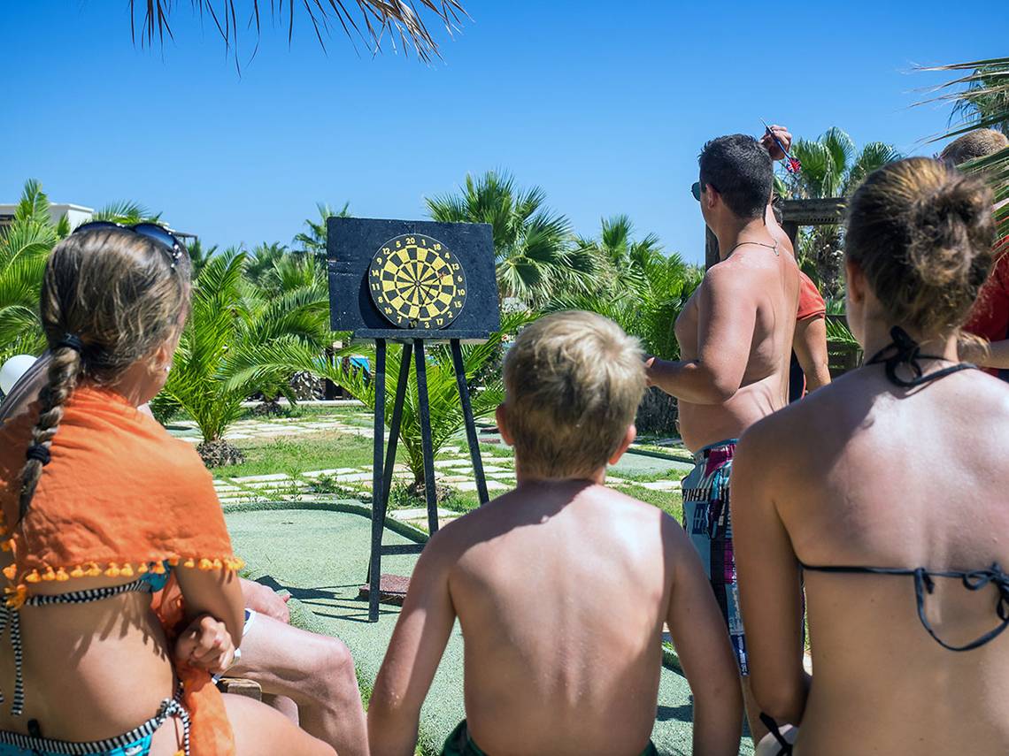 Familie spielt Dartwerfen im Freien im Stella Village Hotel & Bungalows.
