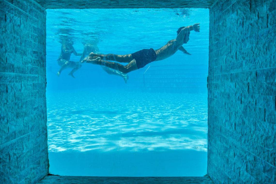 Schwimmbecken des Grand Belish Resort Hotel & Spa mit Personen, die im Wasser schwimmen.