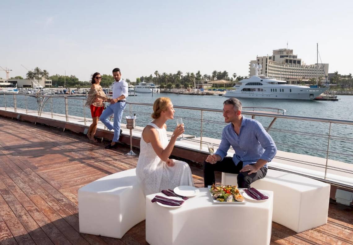JA Lake View Hotel Terrasse mit Paar beim Essen mit Blick auf den Hafen.