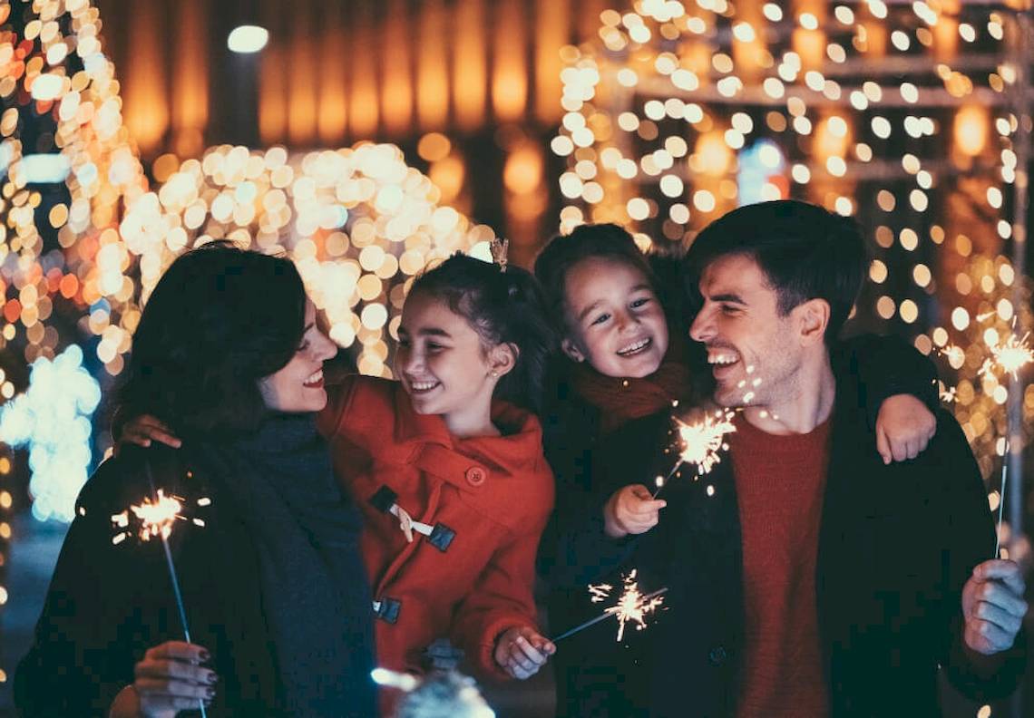 Eine Familie feiert das Fest der Lichter mit Feuerwerk und Lächeln.