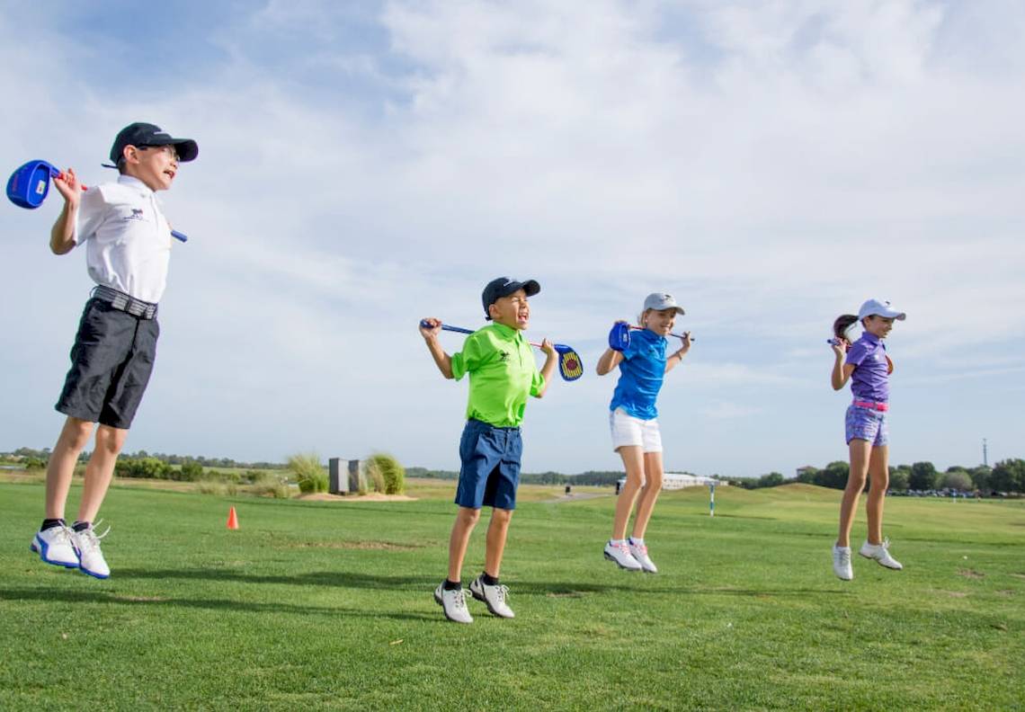 Kinder spielen Golf auf einem Golfplatz am JA Lake View Hotel.