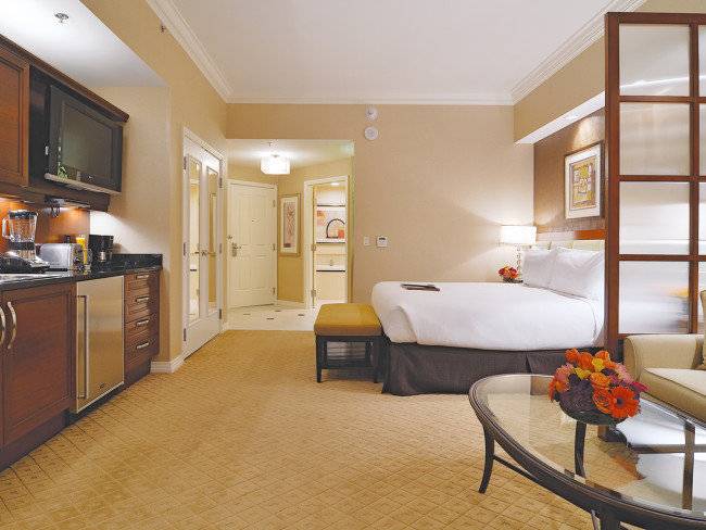 Hotelzimmer im The Signature at MGM Grand mit Bett, Küche und Wohnzimmer.