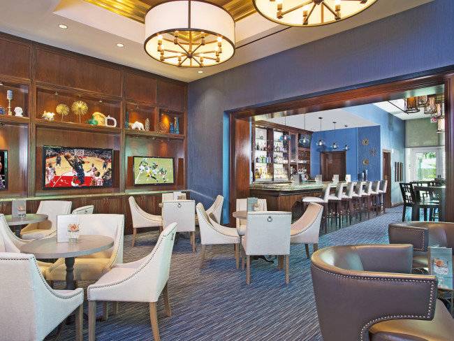 Das Innere des The Signature At MGM Grand Hotels mit einer Bar, Fernsehern und gepolsterten Stühlen.