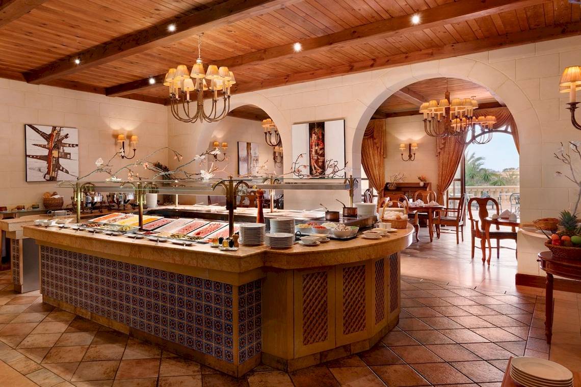 Buffetbereich im Kempinski Hotel San Lawrenz Malta mit verschiedenen Speisen und Möbeln.