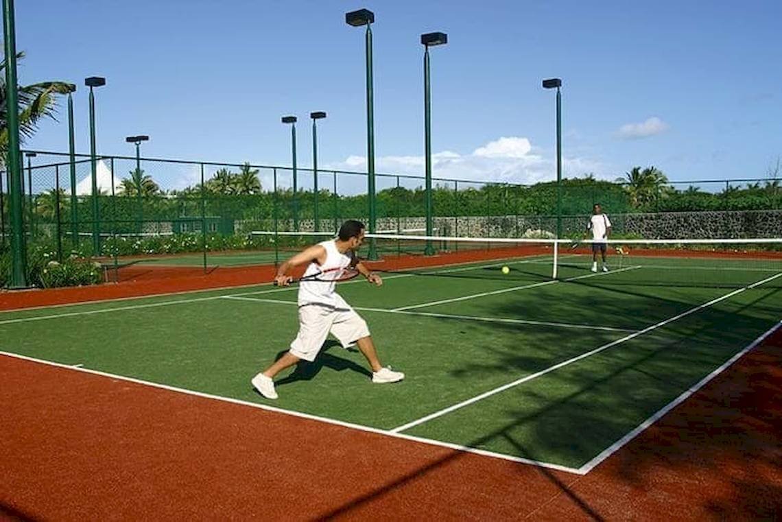 Tennisplatz mit Spielern im Constance Belle Mare Plage Hotel.