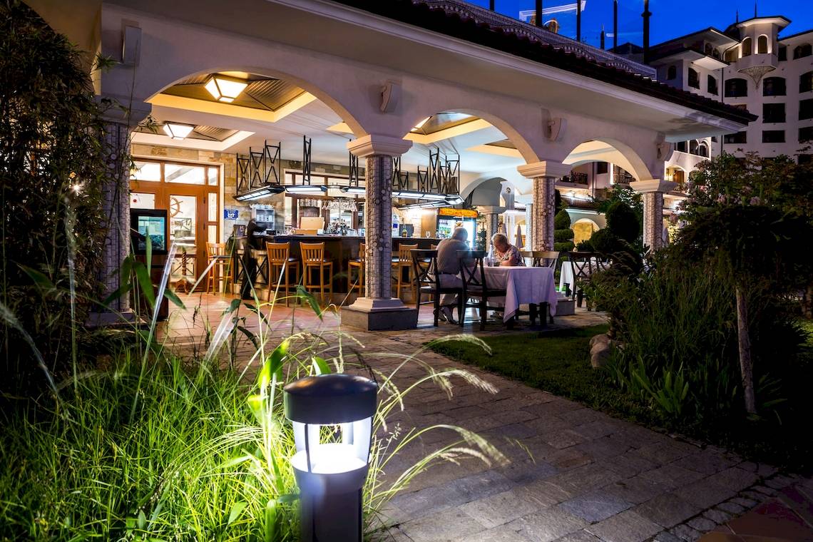 Außenbereich des Helena Sands Hotels mit Gästen bei Nacht.
