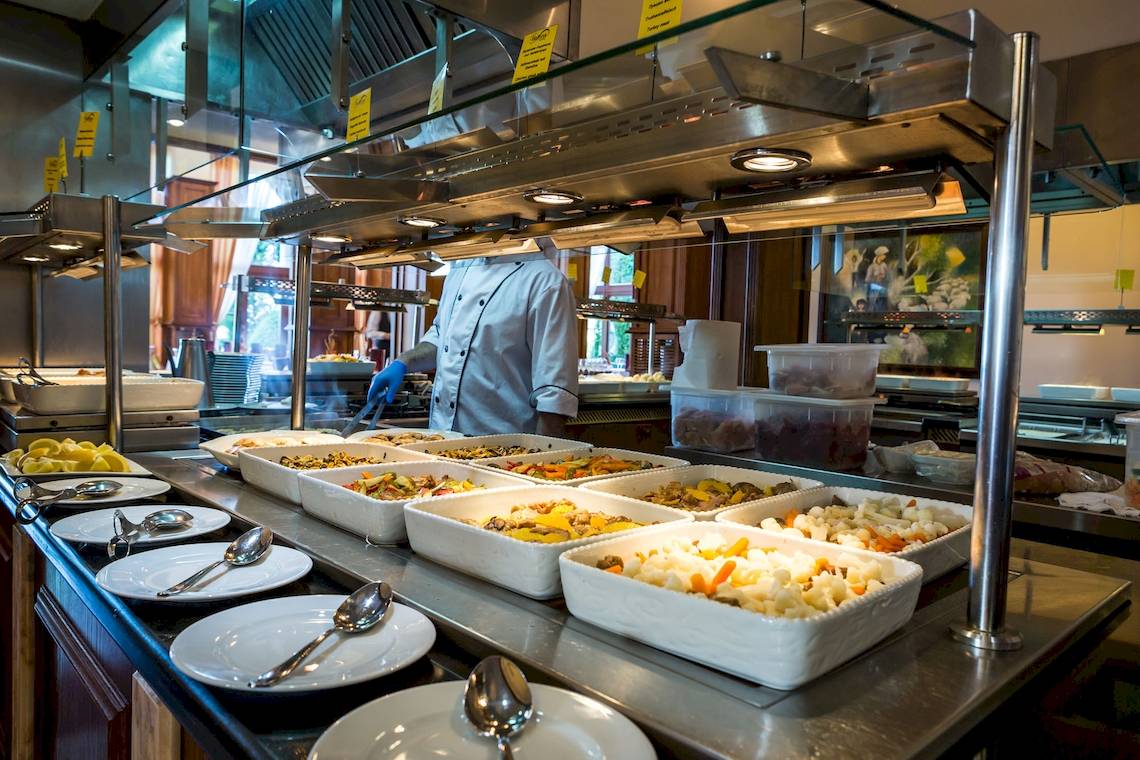 Buffettisch im Hotel Helena Sands mit verschiedenen Gerichten in weißen Schüsseln.