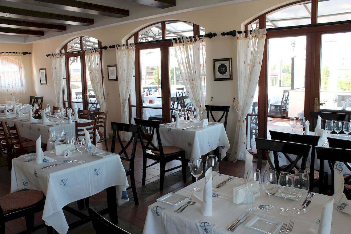 Innenansicht des Restaurants des Helena Sands Hotels mit gedeckten Tischen und Stühlen.
