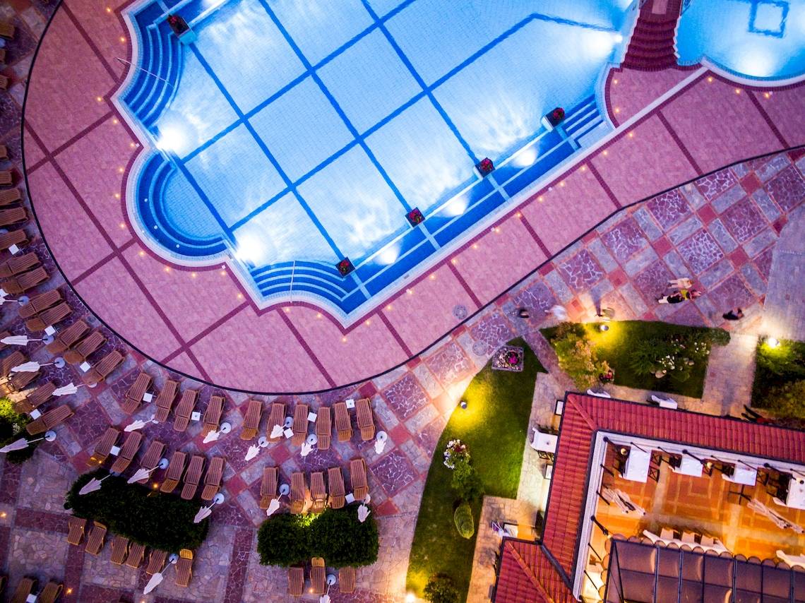 Luftaufnahme des Helena Sands Hotel Pools mit Liegestühlen und Treppen