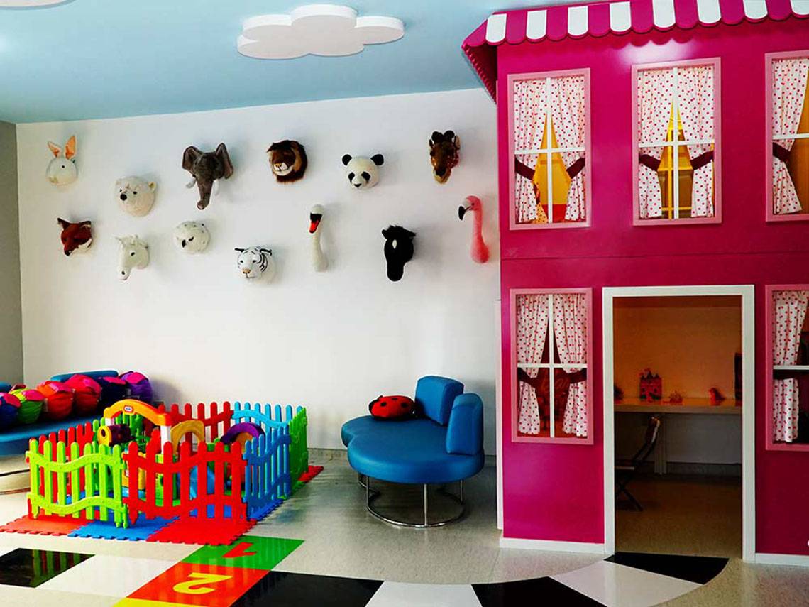 Ein farbenfrohes Kinderzimmer im Sueno Hotels Beach Side mit vielen Tiermasken an der Wand.