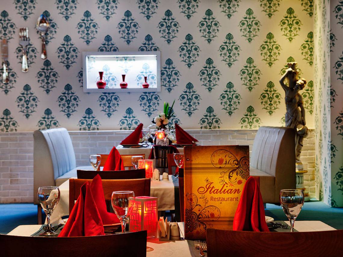 Italienisches Restaurant Tisch mit Servietten und Getränken, dekorative Wandmuster.
