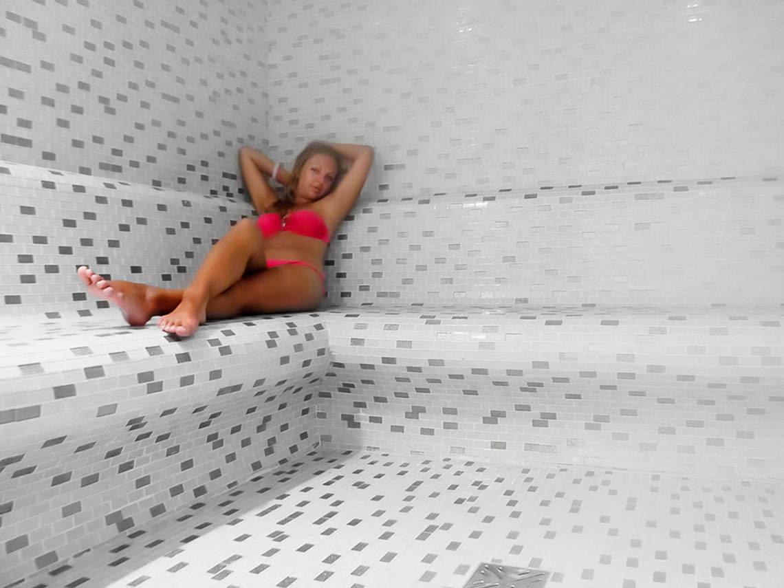 Eine Frau liegt in einer Sauna des Sueno Hotels Beach Side.