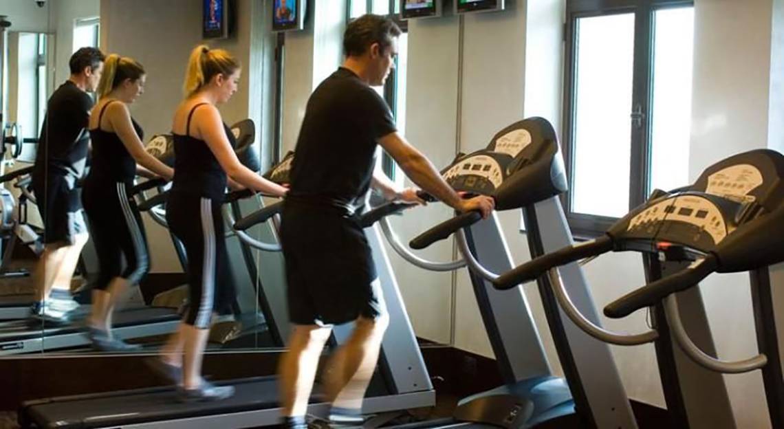 Fitnesscenter im Manzil Downtown Hotel in Dubai mit mehreren Personen auf Laufbändern.