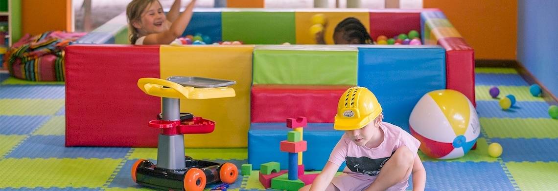 Kinder im Meeru Island Resort spielen in einem bunten Spielbereich mit Bällebad und Spielzeug.