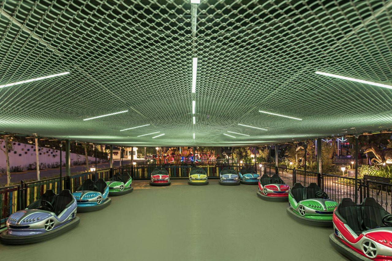 Blick auf die Autoscooter im Delphin BE Grand Resort, unter einem beleuchteten Netzdach in einem unterhaltsamen Bereich.
