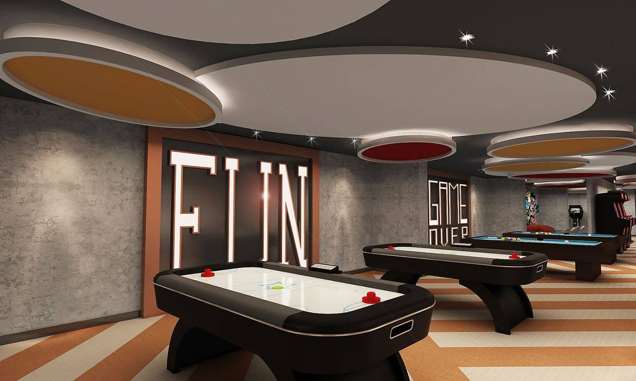 Moderne Spielelounge im Delphin BE Grand Resort mit Airhockey-Tischen und bunten Deckenlichtern.