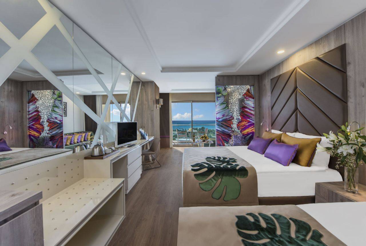 Elegantes Zimmer im Delphin BE Grand Resort mit Meerblick und modernem Dekor in warmen Farben.