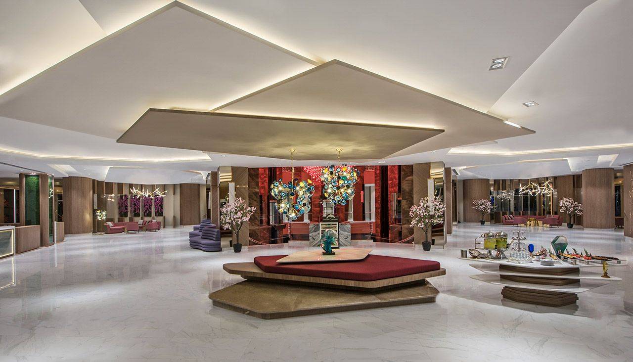 Elegante Hotellobby im Delphin BE Grand Resort mit stilvollem Dekor und modernen Lichtinstallationen.