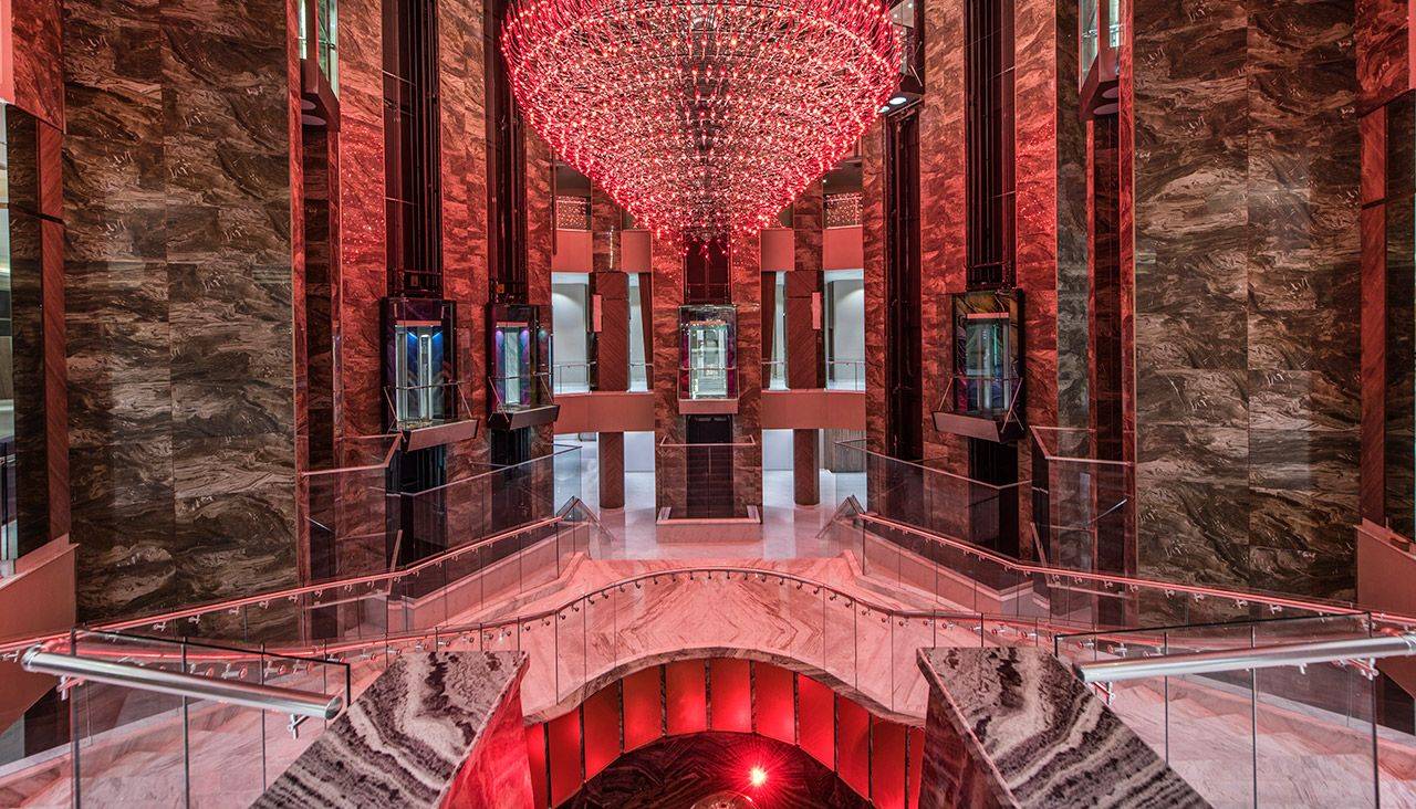 Elegante Hotellobby des Delphin BE Grand Resort mit rotem Kronleuchter und modernem Design.
