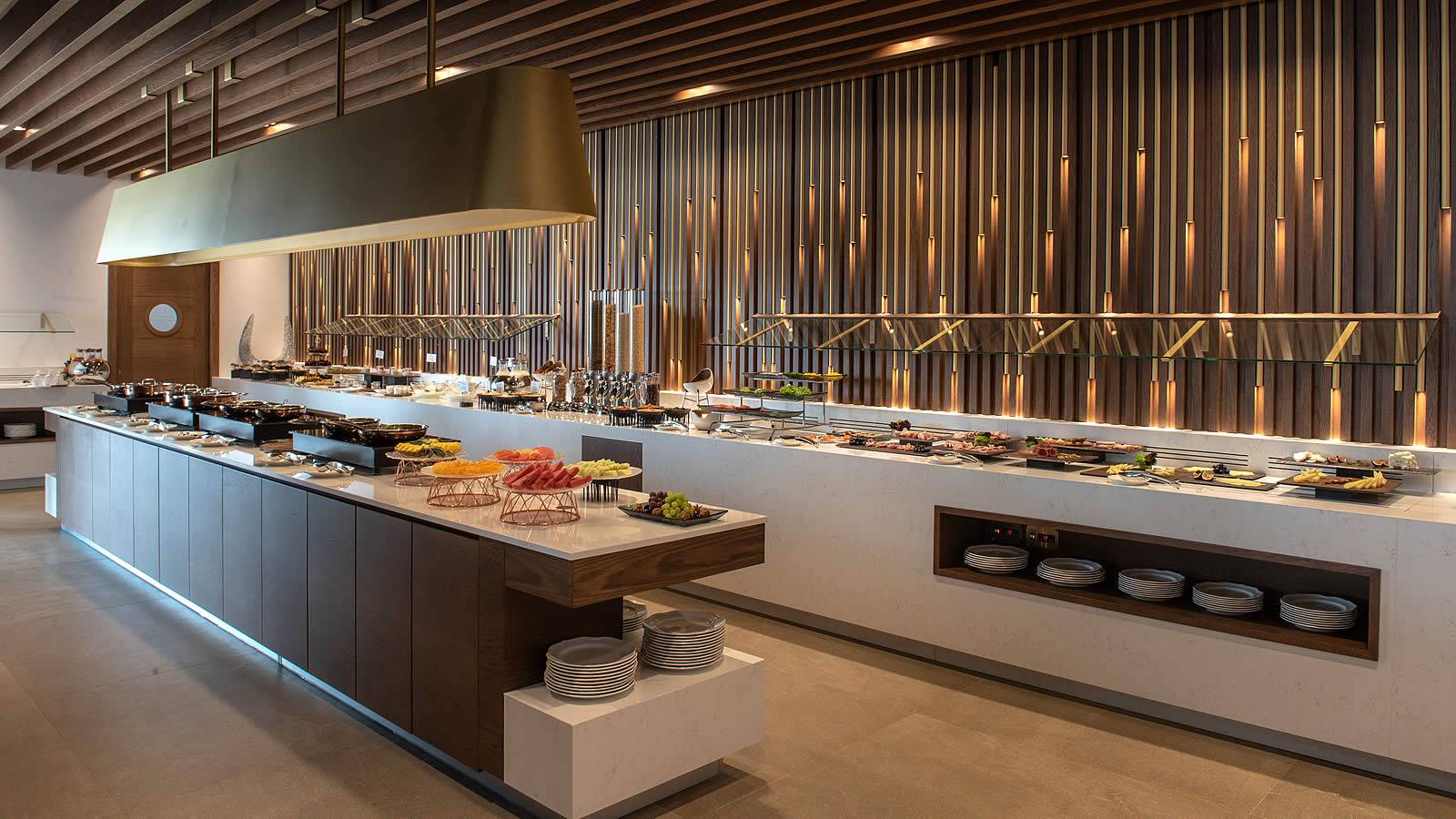 Buffettisch im Nana Princess Suites Hotel mit verschiedenen Speisen und goldenen Säulen.