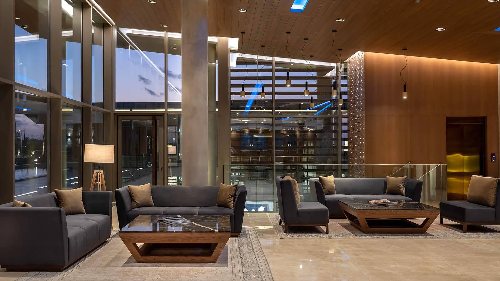 Lobby des Nana Princess Suites, Villas & Spa mit modernen Möbeln und großen Fenstern.