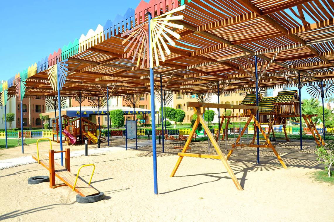 Kinderspielplatz im Sunrise Royal Makadi Resort mit bunten Holzspielgeräten und einem schattigen Pavillon.