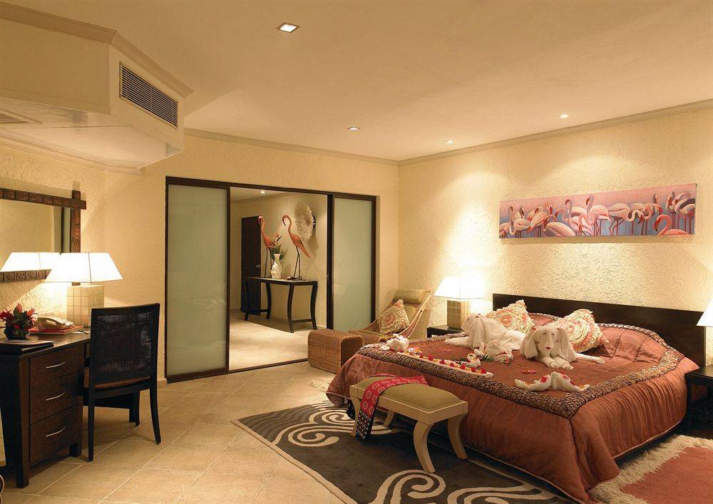 Hotelzimmer im Diani Reef Beach Resort & Spa mit Bett, Schreibtisch, Sessel und Panoramafenster.