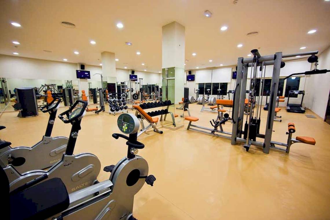 Fitnessstudio im Majestic Elegance Punta Cana mit verschiedenen Geräten und Trainingsgeräten.