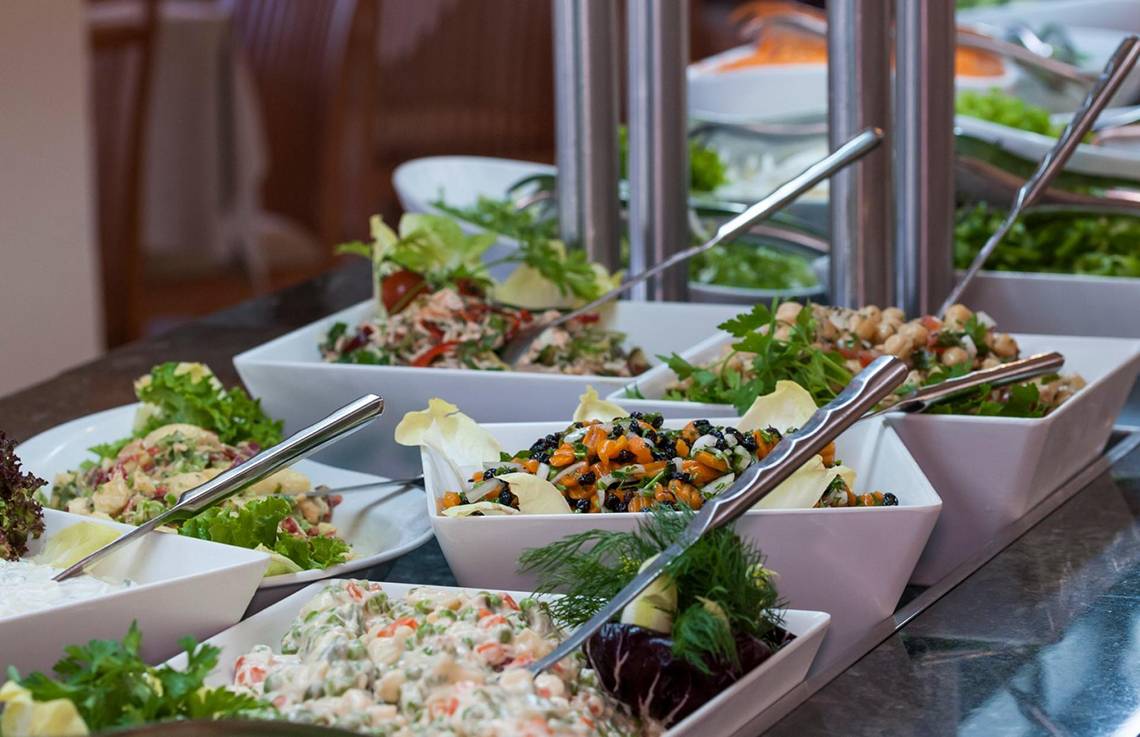 Buffet-Tisch im Apollo Beach Hotel mit verschiedenen Salaten und Gerichten.