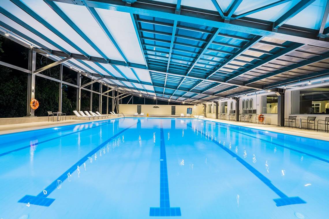 Apollo Beach Hotel Schwimmbad bei Nacht mit blauer Beleuchtung und Liegestühlen