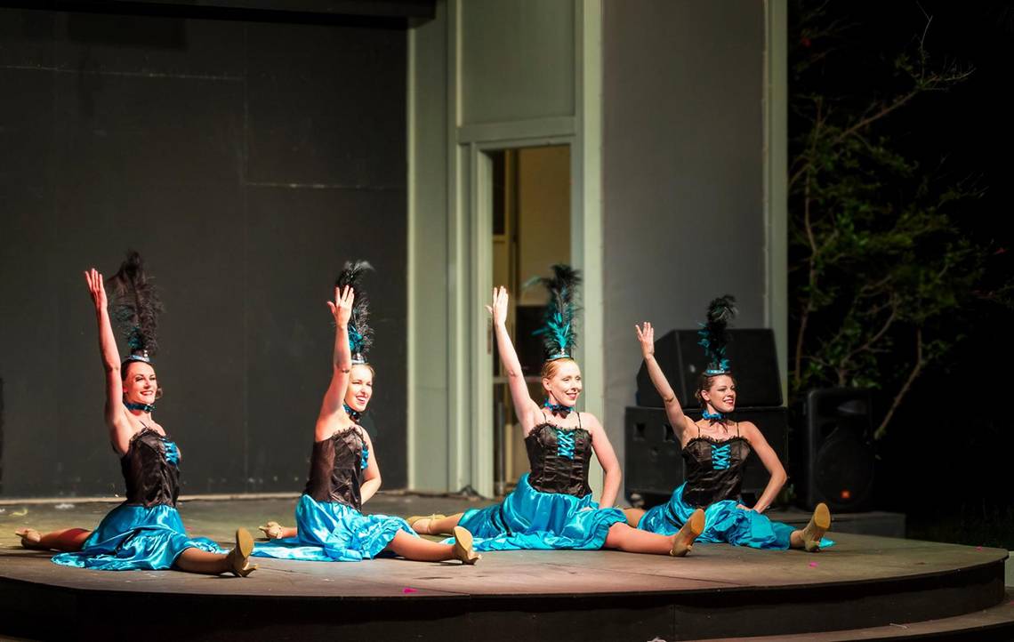 Vier Frauen in blauen Kleidern tanzen auf der Bühne des Apollo Beach Hotels.